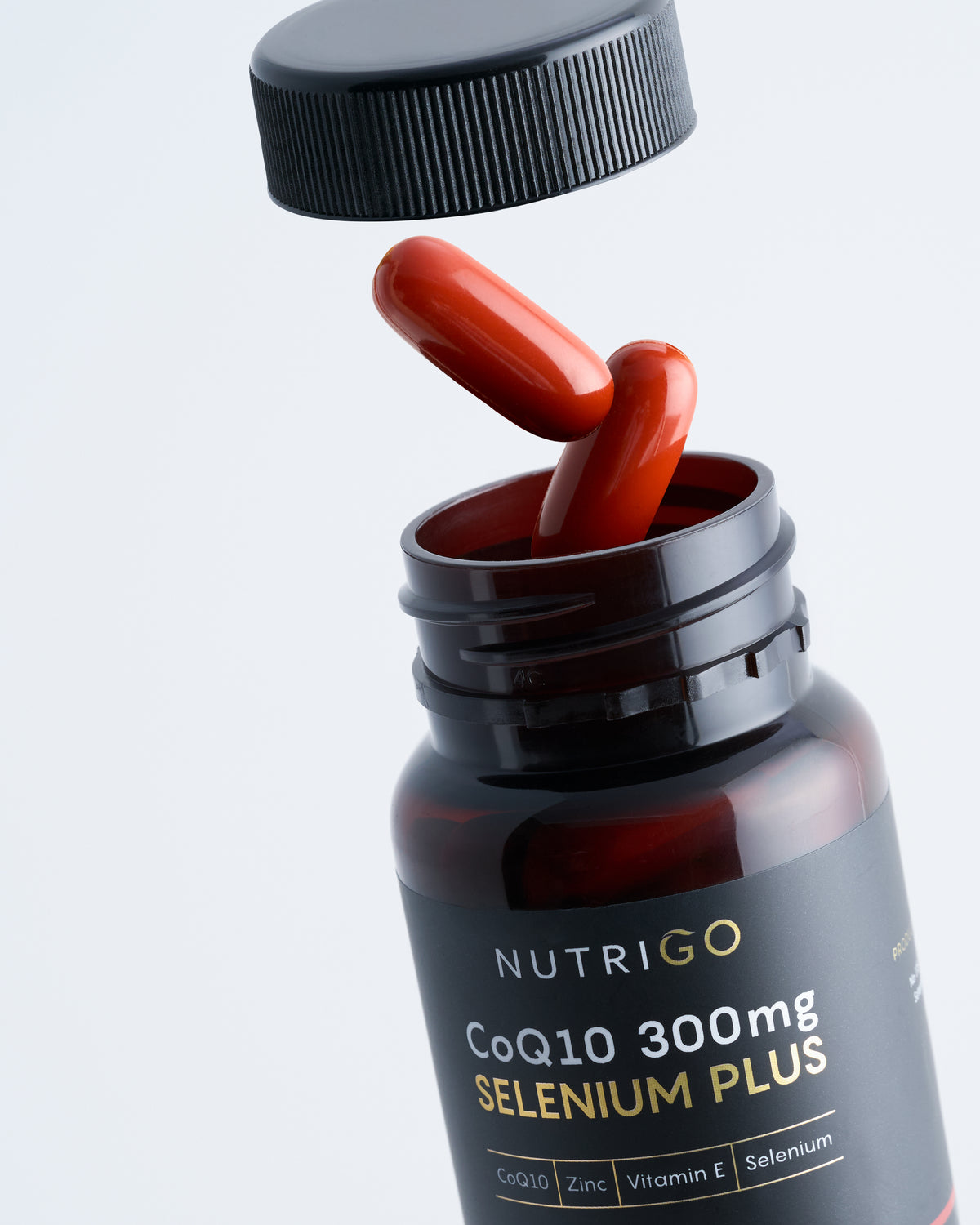CoQ10 Selenium Plus 300mg by Nutrigo – open amber bottle with red softgels and cap lifted off