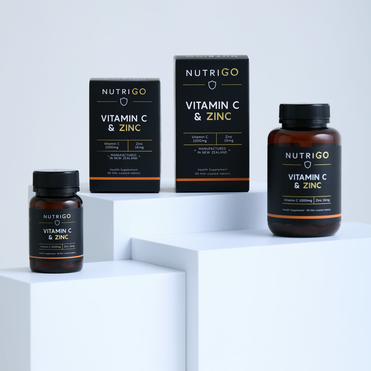 Vitamin C + Zinc 1000mg by Nutrigo – 30- and 90-tablet boxes and bottles on white display blocks