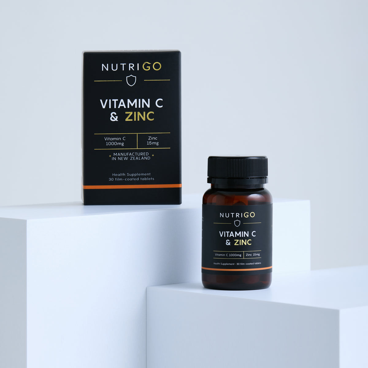 Vitamin C + Zinc 1000mg by Nutrigo – 30-tablet box and amber bottle on white display blocks